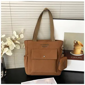 Detailansicht der großen braunen Canvas-Tasche mit Metallschnalle und kleiner Geldbörse