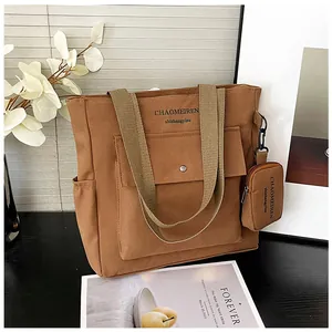 Große braune Canvas-Tragetasche mit Vordertasche und passendem Mini-Beutel im Detail