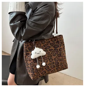 Détail de sac cabas léopard avec lanières brunes et pendentif nuage en peluche doux