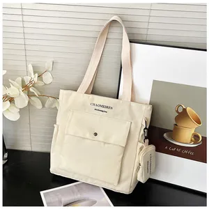 Detail der cremeweißen Canvas-Einkaufstasche mit Vordertasche und Mini-Münzfach-Anhänger