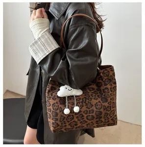 Détail du grand sac cabas à imprimé léopard avec charm nuage porté à l'épaule