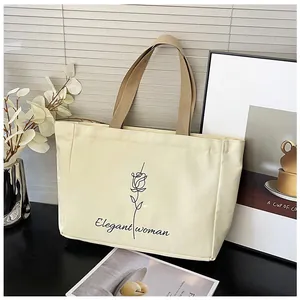 Détail du motif rose élégant et du texte sur le sac cabas en toile beige