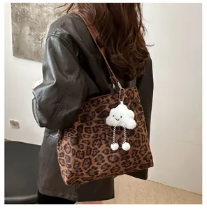 Détail du sac cabas imprimé léopard avec un pendentif nuage en peluche doux