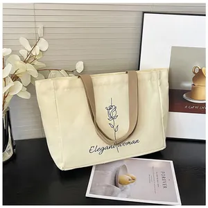 Détail du sac fourre-tout en toile blanc cassé avec rose et poignées marron