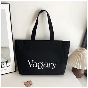 Gros plan de l'imprimé Vagary sur un sac cabas en toile noire dans un décor minimaliste