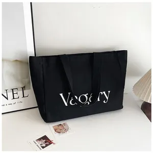 Détail du sac fourre-tout en toile noire avec texte Vagary blanc pour le quotidien