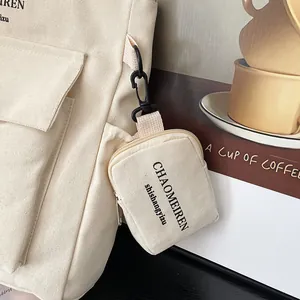 Vielseitige cremefarbene Canvas-Einkaufstasche mit kleiner Geldbörse und schwarzem Text