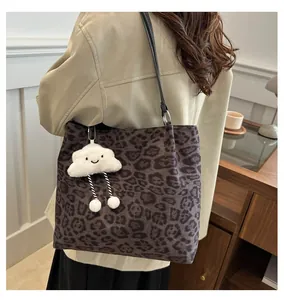 Vue latérale détaillée d'un sac cabas léopard avec un pendentif nuage porté par un mannequin