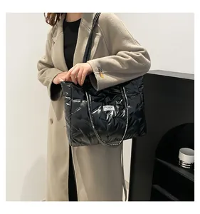 Macro detail of black quilted tote bag texture with fashion label and winter coat styling