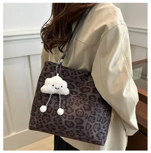 Détail du sac cabas léopard avec pendentif nuage en peluche et bandoulières en cuir