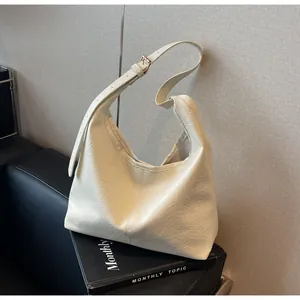 Detail of hobo shoulder bag featuring wrinkled leather texture and adjustable gold buckle