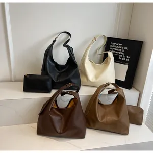 Detail view of the minimalist crescent tote bag set in four neutral leather colors