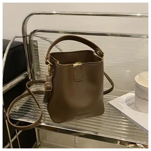 Détail du sac seau marron café mat avec inscription Fashion sur présentoir chic