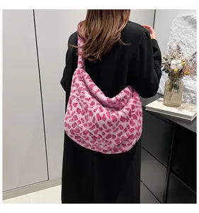 Vue arrière d'un mannequin portant un grand cabas en peluche rose à motif léopard