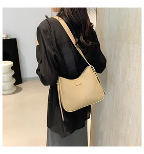 Dettaglio borsa a mezzaluna beige con placca FASHION e cucitura verticale decorativa