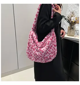 Pink leopard print plush hobo bag detail with wide fuzzy shoulder strap on model