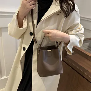 Sac seau marron foncé tendance avec bandoulière réglable et détails métalliques