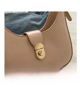 Detail of the golden metal twist lock and smooth beige PU leather texture of this bag