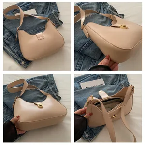 Detail view of cream hobo shoulder bag featuring golden metallic buckle and smooth leather texture