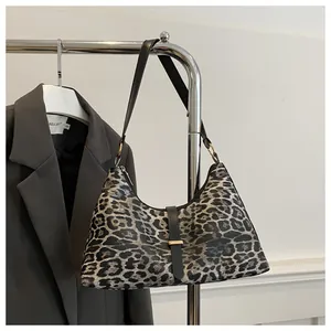 Vue détaillée du sac à bandoulière léopard avec boucles dorées et lanière en cuir noir
