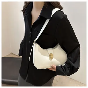 Detail of white half-moon underarm bag with gold metal twist lock and matte leather finish