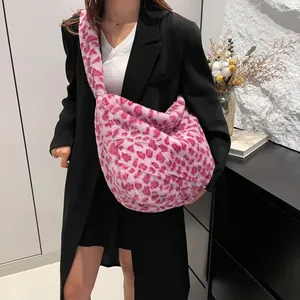 Sac hobo en peluche imprimé léopard rose avec large bandoulière dans un décor élégant