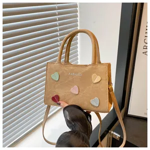 Detail of camel crossbody bag with colorful heart patches and Fashion text print