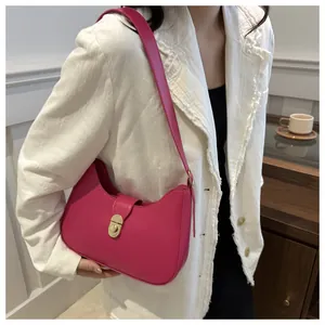 Close-up of magenta crescent shoulder bag featuring a classic gold-tone oval twist lock
