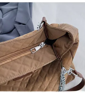 Detailaufnahme des glatten Silberreißverschlusses und Steppmusters der Khaki-Tasche