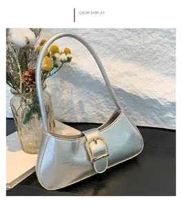 Borsa baguette argento con trama increspata e fibbia dorata su sfondo bianco elegante