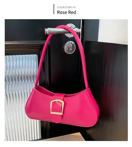 Dettaglio borsa baguette rosso rosa con fibbia dorata appesa alla maniglia nera