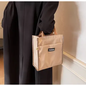 Close-up of waterproof lunch bag with black FASHION label and front zipper pocket