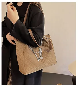 Detail der khakifarbenen Stepp-Tote-Bag mit Kettenriemen und Leder-Schultergriff