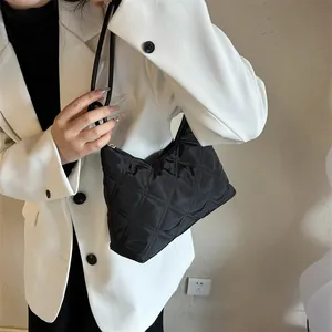 Close-up of black quilted shoulder bag featuring elegant diamond lattice stitching details