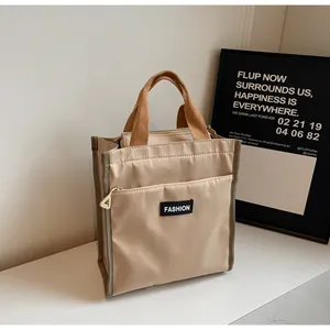 Detail of minimalist beige nylon lunch bag with front zipper pocket and brown handles