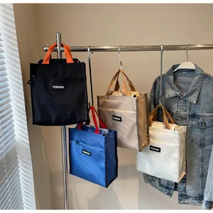 Detailed display of assorted nylon lunch tote bags in black, blue, khaki, and white colors