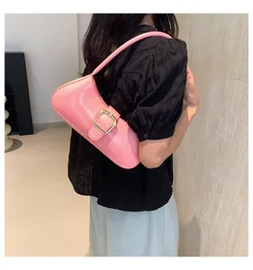 Dettaglio borsa baguette rosa in pelle verniciata con fibbia rettangolare dorata