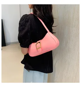 Dettaglio ravvicinato della borsa hobo in pelle rosa con fibbia decorativa in metallo dorato