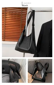 Detail of black PU leather hobo bag with HIS HIS embossed lettering and wide strap