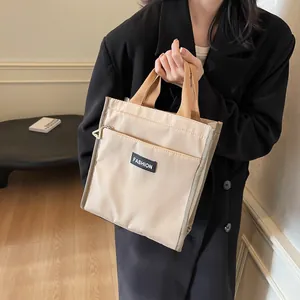 Chic beige waterproof lunch bag with brown handles and front zipper pocket for work