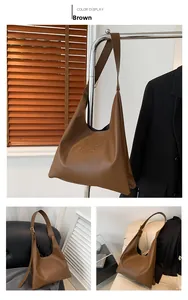 Detailed view of brown PU leather shoulder bag with embossed texture and wide strap