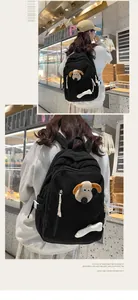 Gros plan d'un sac à dos noir en velours côtelé avec pendentif chien et os décoratif