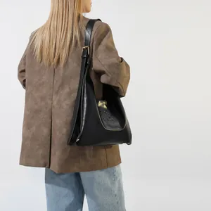 Detail of black quilted shoulder bag featuring embossed HIS HIS lettering and metal buckle