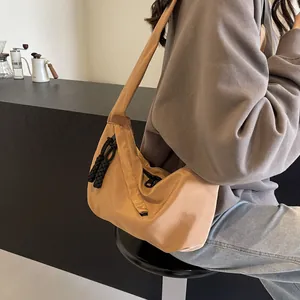 Detail of khaki crescent shoulder bag with smooth nylon finish and woven zipper pull