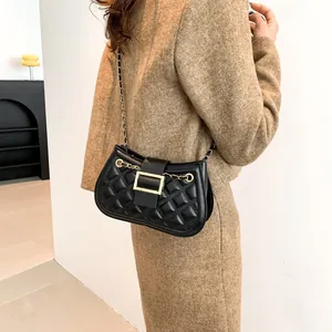 Classic black quilted shoulder bag with gold hardware and chain strap on a model