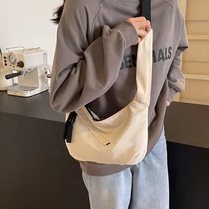 Detail of a minimalist off-white soft fabric tote bag with black wide woven strap