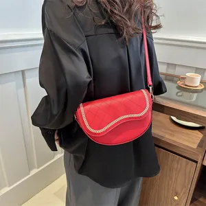 Détail de la sacoche de selle rouge matelassée avec chaîne dorée et bandoulière réglable