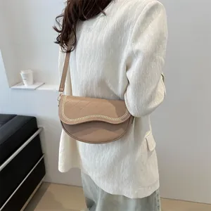 Détail du sac selle marron clair avec motif matelassé en losanges et broderie chaîne