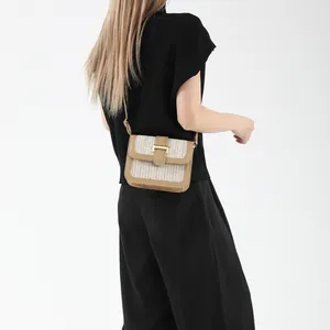 Detail of woven fabric crossbody bag with camel leather trim and gold buckle closure