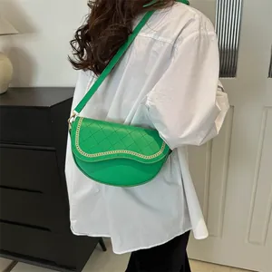 Détail du sac selle vert avec surpiqûres en losanges et garniture en chaîne dorée chic